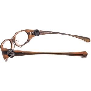 May include: Brown plastic framed glasses with a black temple tip and the text "Eyeglassescout.com" on the temple.