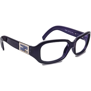 May include: Purple plastic framed eyeglasses with clear lenses and a small gold and blue crystal embellishment on the left temple.