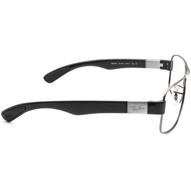 Puede incluir: Gafas Ray-Ban negras y plateadas con montura de pl&aacute;stico negro y patillas de metal. Las patillas est&aacute;n grabadas con el logotipo de Ray-Ban.