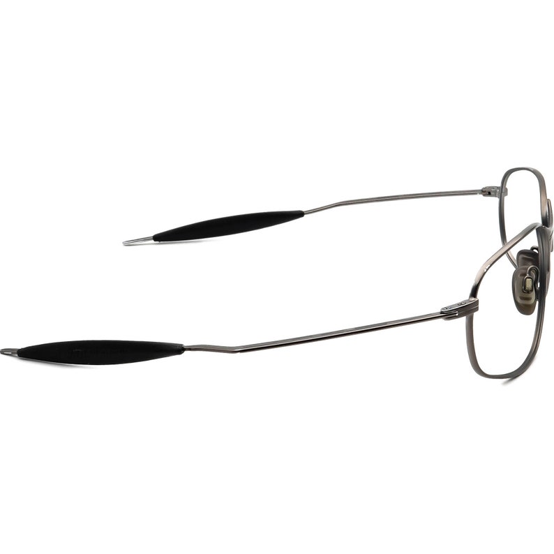 May include: A pair of eyeglasses with a silver metal frame and black earpieces. The glasses have a rectangular shape and are designed for vision correction. The image is a side view of the glasses.
