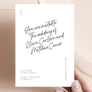 Puede incluir: Una invitación de boda blanca con texto en caligrafía negra. El texto dice "Usted está invitado a la boda de Olivia Carlson y Matthew Canor". La fecha y hora de la boda se enumeran como "16 de julio de 20XX a las seis en punto" y la ubicación es "Secret Casa Hotel, Florida, CA". El texto "Recepción a continuación" también está incluido.