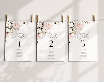 May include: Three white table cards with pink floral designs and black calligraphy. The cards are numbered 1, 2, and 3. Each card lists a table seating chart with names.