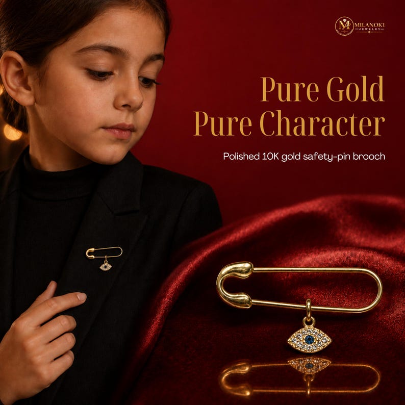 May include: A polished 10K gold safety-pin brooch featuring a dangling eye-shaped charm. The charm is encrusted with small white stones and a single blue stone in the center. The text on the image reads Pure Gold Pure Character Polished 10K gold safety-pin brooch.