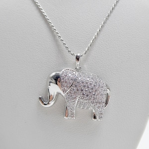 May include: A silver necklace with a diamond-encrusted elephant pendant.