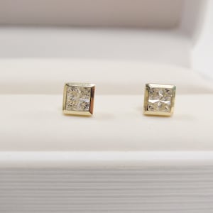 May include: A pair of gold earrings with square-shaped settings and clear princess-cut diamonds.