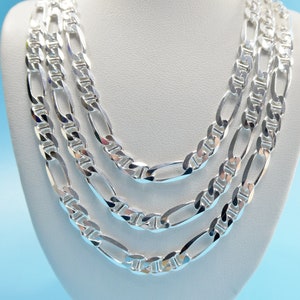 May include: A silver chain necklace with three different sized links. The chain is layered on a white mannequin bust.