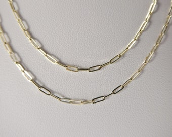 May include: Two gold chain necklaces with a linked chain pattern. The chains are layered on top of each other.
