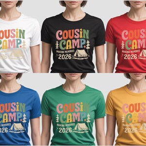 May include: A collection of t-shirts in various colors, each featuring the text "COUSIN CAMP" in colorful letters, along with "MAKING MEMORIES 2026" and a tent graphic. The shirts are white, black, red, blue, green, and yellow.