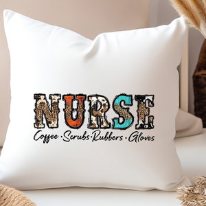 May include: White throw pillow with the word "NURSE" in colorful patterned letters. The letters are decorated with animal print designs. The text "Coffee Scrubs Rubbers Gloves" is written below the word "NURSE".