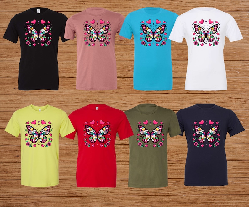 May include: Eight t-shirts with a colorful butterfly design on the front. The shirts are in different colors, including black, pink, blue, white, yellow, red, green, and navy.