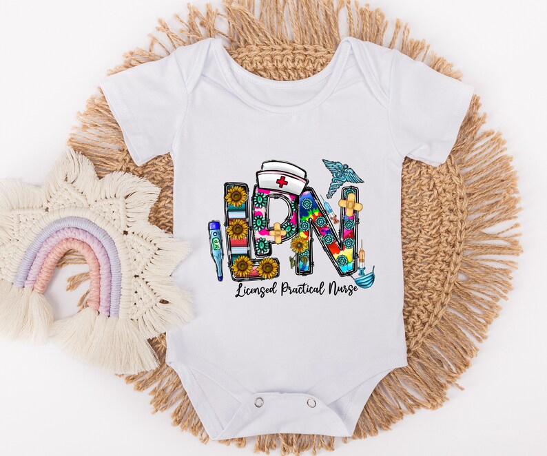 Peut inclure: Combinaison blanche pour b&eacute;b&eacute; avec un graphique color&eacute; des lettres LPN, compos&eacute; de symboles m&eacute;dicaux et de tournesols. Le texte "Licensed Practical Nurse" est sous le graphique.