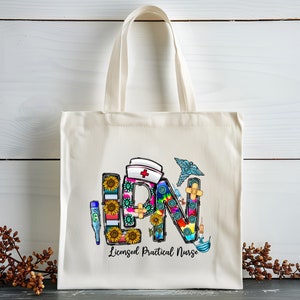 Peut inclure: Un sac fourre-tout en toile blanche avec un graphique color&eacute; des lettres "LPN" compos&eacute; de divers symboles m&eacute;dicaux et du texte "Infirmi&egrave;re auxiliaire dipl&ocirc;m&eacute;e".