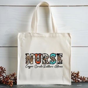 May include: A white canvas tote bag with the word "NURSE" printed in colorful letters with a leopard print design. The text "Coffee. Scrubs. Rubbers. Gloves" is printed below the word "NURSE".