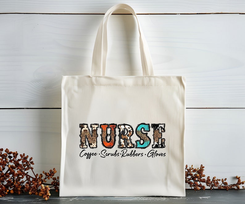May include: A white canvas tote bag with the word "NURSE" printed in colorful letters with a leopard print design. The text "Coffee. Scrubs. Rubbers. Gloves" is printed below the word "NURSE".