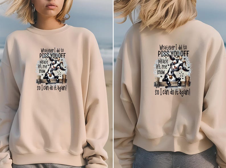 May include: Beige sweatshirt with a graphic of a goat on a fence and the text "Whatever I did to PISS YOU OFF, please let me know so I can do it again!" on the front and back. The sweatshirt is a neutral color.