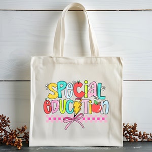 May include: A white canvas tote bag with a colorful graphic that says "Special Education" with a pencil, apple, and flowers.