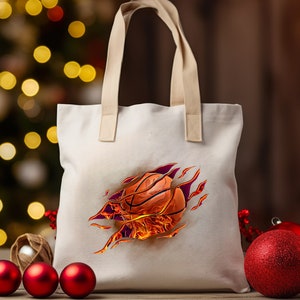 May include: A white canvas tote bag with a design of a basketball on fire. The basketball is orange and black with red flames.