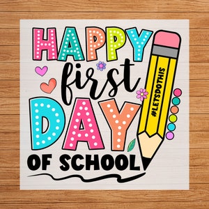 May include: A colorful graphic with the text "HAPPY FIRST DAY OF SCHOOL" in various colors and fonts. A yellow pencil with the text "#LETSDOTHIS" is on the right. The design includes hearts, flowers, and dots.