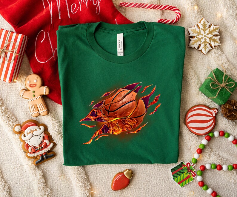 May include: Green t-shirt with a basketball bursting out of the fabric, surrounded by flames. The basketball is orange and brown with black lines.