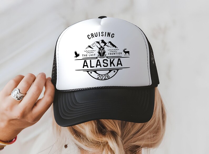 A person wearing a black and white baseball cap with a printed design on it.