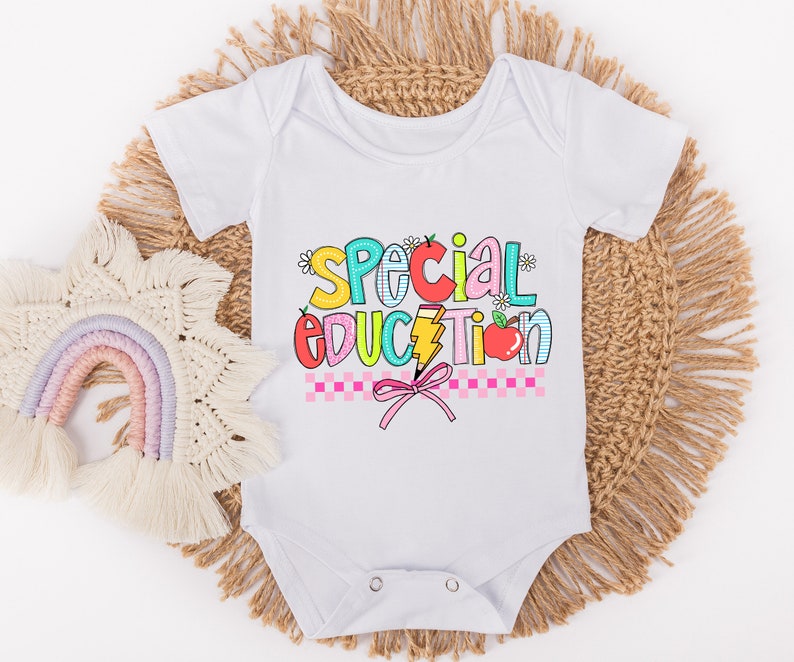 May include: White baby onesie with a colorful graphic that says "Special Education" with a pink bow and a red apple.