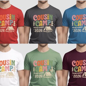 May include: A collection of short-sleeved t-shirts in various colors, each featuring the text "COUSIN CAMP MAKING MEMORIES 2026" in a colorful, playful font. The design includes a tent and trees, suggesting a camping theme.