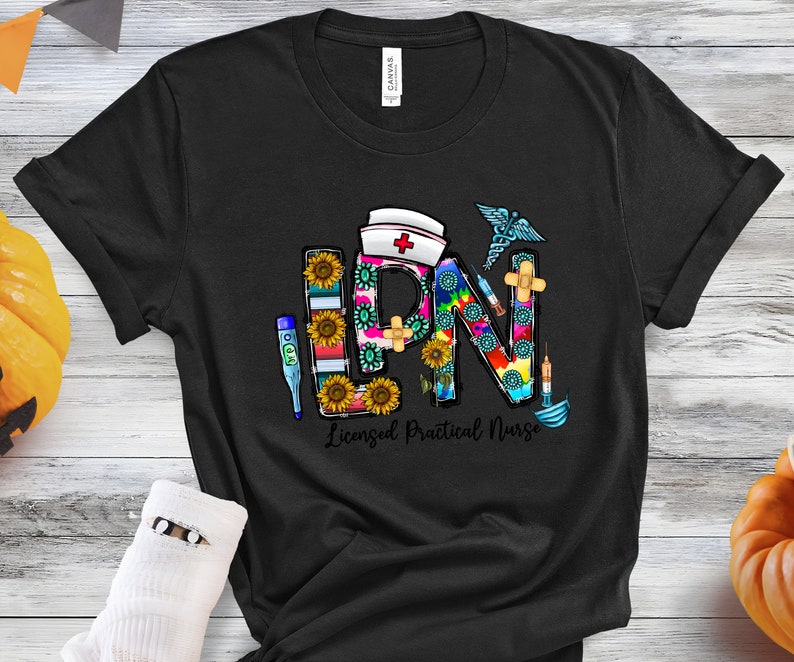 Peut inclure: T-shirt noir avec un graphique color&eacute; des lettres LPN, repr&eacute;sentant une infirmi&egrave;re auxiliaire dipl&ocirc;m&eacute;e, avec des symboles m&eacute;dicaux et des tournesols.