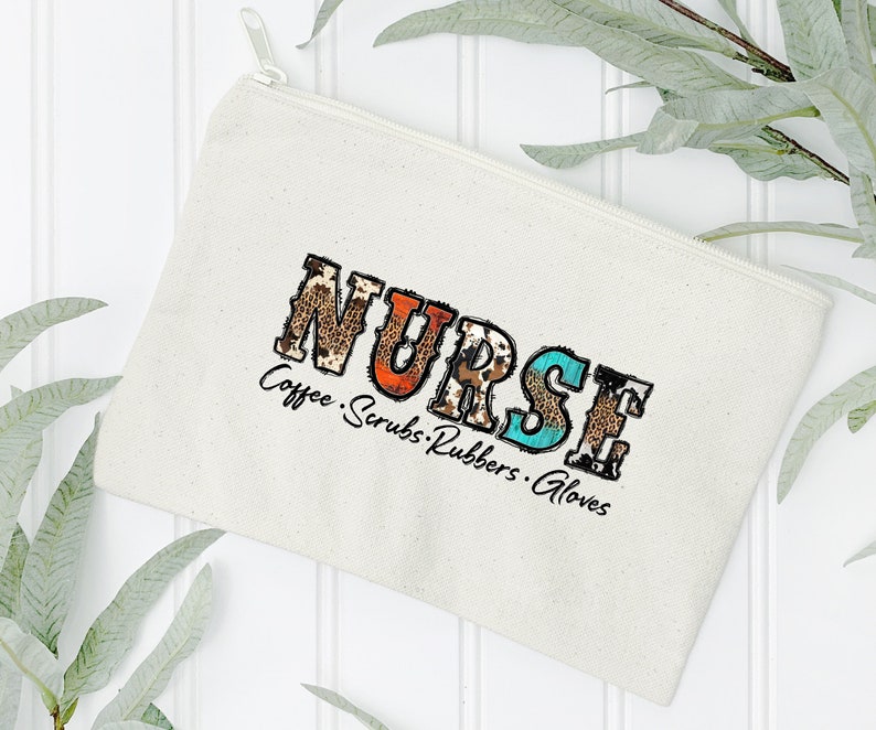 May include: A white canvas zippered pouch with the word "NURSE" in colorful patterned letters. The text "Coffee. Scrubs. Rubbers. Gloves" is printed below the word "NURSE".