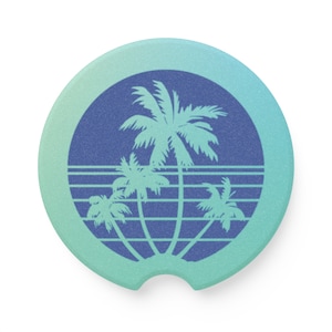 May include: A blue and green round coaster with a retro design featuring four palm trees and a horizon line.