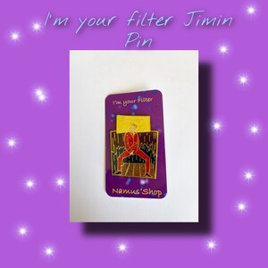 May include: A gold and black enamel pin featuring a cartoon illustration of a man in a red suit and black pants. The pin has the text "I'm your filter" and "Namus'Shop" on it.