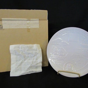 May include: A white ceramic plate with a raised design commemorating the Bicentennial of America's War for Independence. The plate features images of the "Kings Mountain", "Fort Griswold", "Green Mountain Boys", and "The Yorktown" battles. The plate also includes the text "Bicentennial Celebration Victories for Independence" and "United States of America".