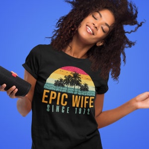 May include: Black t-shirt with a retro sunset graphic and the text "Epic Wife Since 1972".