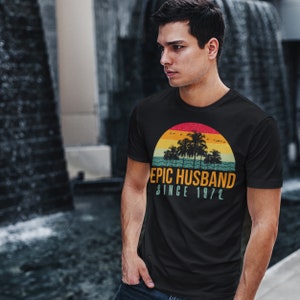 May include: A black t-shirt with a retro sunset graphic and the text "EPIC HUSBAND SINCE 1972".