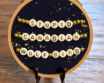 Heated Rivalry “Stupid Canadian Wolf Bird” embroidery hoop (friendship bracelet)