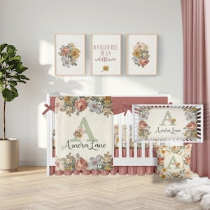 May include: A floral-themed nursery set, featuring a cot, bedding, and wall art. The cot has a floral-patterned blanket and skirt, with a matching pillow and wall art. The wall art includes framed floral prints and a quote. The colour scheme is soft, with pinks, greens, and creams.