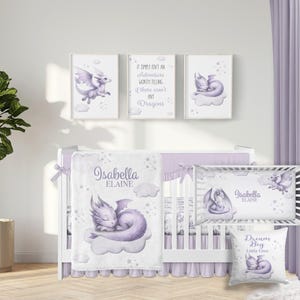 May include: A nursery set with a white crib, bedding, and decorative items. The set includes a blanket, crib bumper, and pillow with dragon illustrations in shades of purple. Wall art features dragon images and text: "It simply isn't an adventure worth telling if there aren't any Dragons."