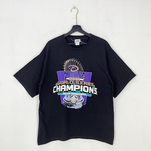 May include: Black t-shirt featuring a graphic of the 2001 World Series trophy. The design includes the text "WORLD SERIES CHAMPIONS" and "ARIZONA DIAMONDBACKS". The shirt is a vintage Lee brand.