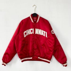 May include: A set of three ceramic mugs with a speckled, matte finish. Each mug features a different color: light blue, cream, and gray. The mugs have a simple, modern design with a rounded shape and a comfortable handle.