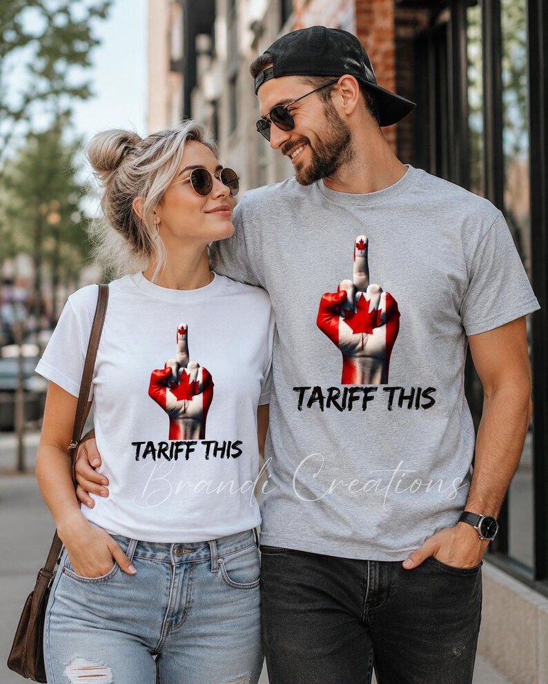 Puede incluir: Una camiseta blanca y una camiseta gris jaspeado, cada una con un gr&aacute;fico de una mano pintada con la bandera canadiense haciendo un gesto de dedo medio, con el texto TARIFF THIS impreso en letras negras debajo del gr&aacute;fico en ambas.