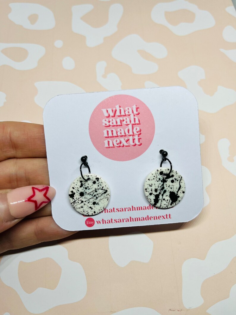 White and black paint splatter polymer clay disc earrings on black brass ball studs.