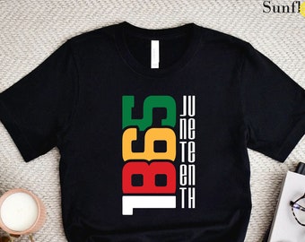 May include: Black t-shirt with a graphic design of the words "Juneteenth 1865" in red, yellow, green, and white.