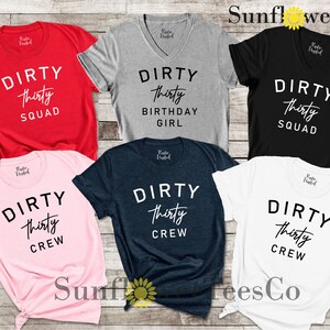 May include: Six different t-shirts with the text "Dirty Thirty" and variations of the text, including "Squad", "Birthday Girl", and "Crew". The shirts are in various colors, including red, grey, black, pink, navy blue, and white.
