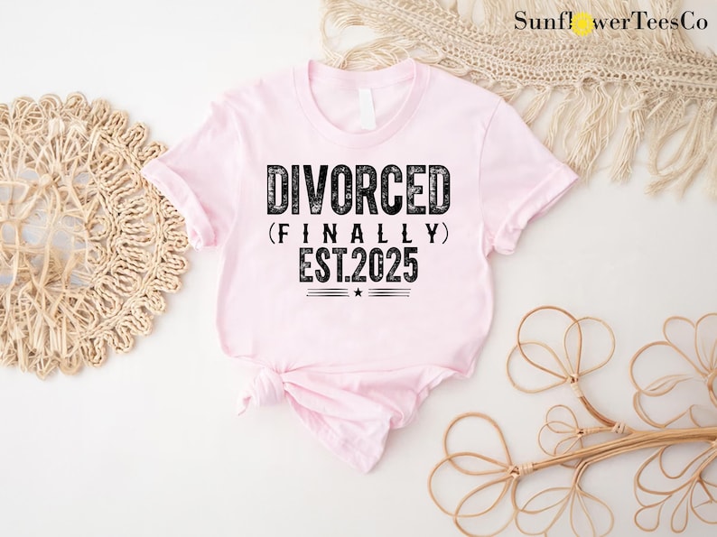 May include: Pink t-shirt with black text that reads "DIVORCED (FINALLY) EST.2025".