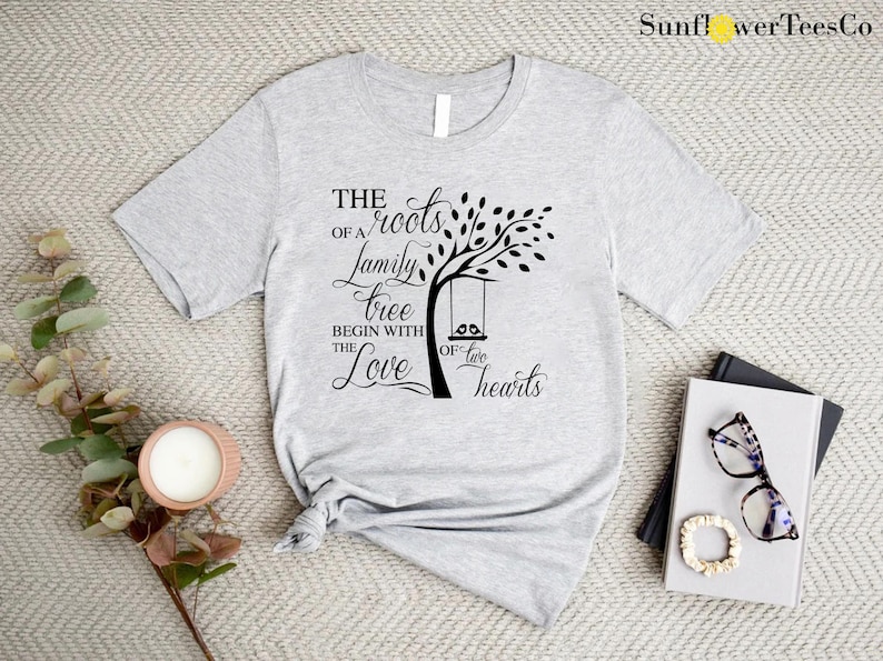 a t - shirt with a tree on it next to a pair of sunglasses
