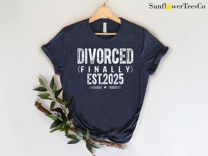 May include: A navy blue t-shirt with white text that reads "DIVORCED (FINALLY) EST.2025".