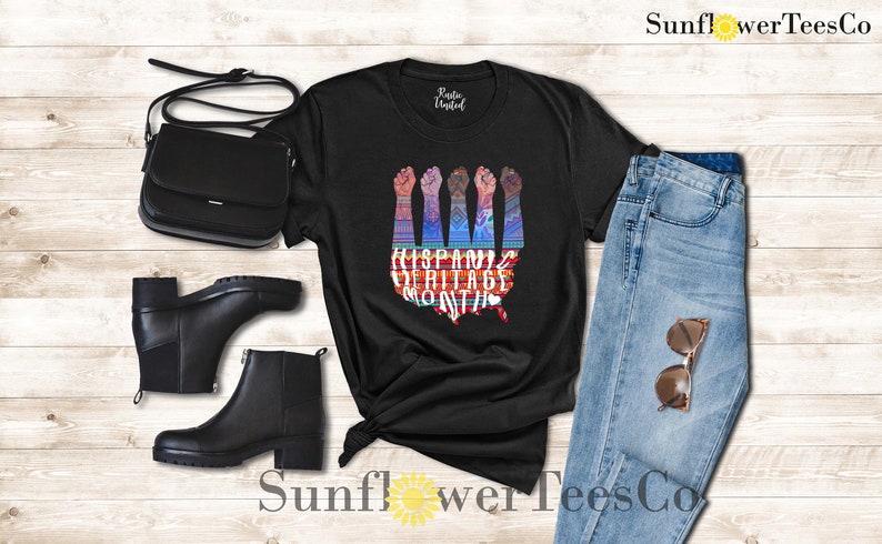 May include: Black t-shirt with a graphic of raised fists forming the shape of the United States. The graphic is colorful and includes the text "Hispanic Heritage Month".