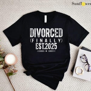 May include: Black t-shirt with white text that reads "DIVORCED (FINALLY) EST.2025".