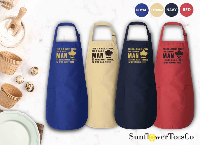 May include: Four kitchen aprons in different colors: royal blue, natural beige, navy blue, and red. Each apron has a pocket and a printed design that says "This is a manly apron for a manly man doing manly things with manly food".