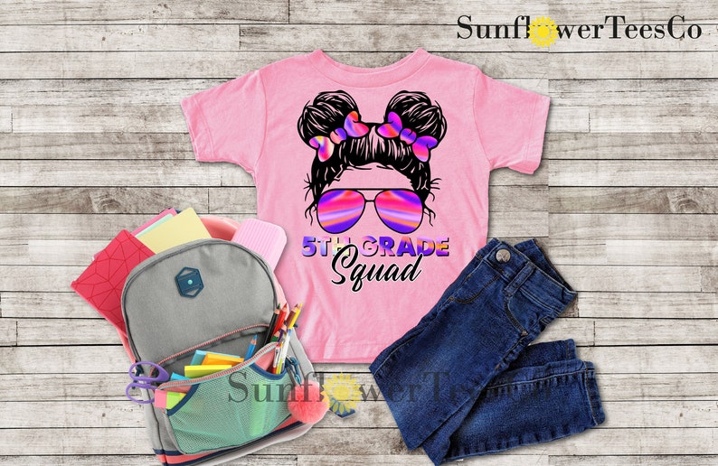 May include: Pink t-shirt with a graphic of a girl with pigtails wearing sunglasses and the text "5th Grade Squad".