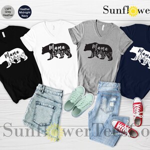May include: Four V-neck t-shirts with a black bear silhouette and the word "Mama" printed on them. The shirts are in black, white, heather grey, and navy blue.